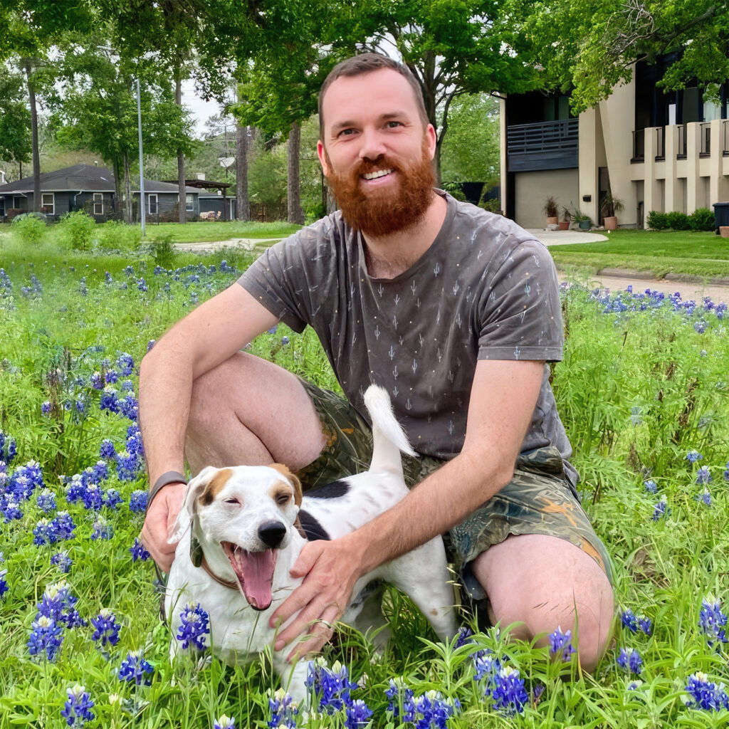 Owner of Decorful and loyal dog in a serene bluebonnet field.